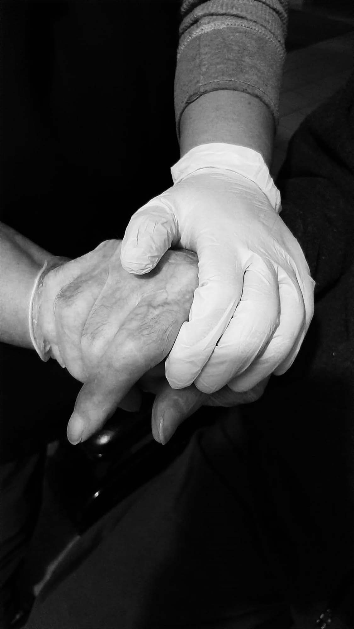 A gloved hand holding another ungloved hand